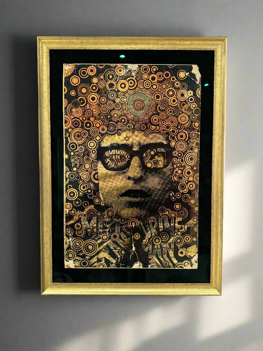 A framed vintage 1968 Bob Dylan 'Mr Tambourine Man' poster with intricate gold patterns and text, displayed in a gold frame.