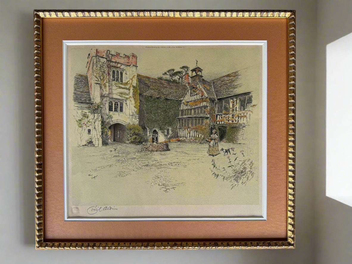 Framed colour print of a village scene with architectural details.