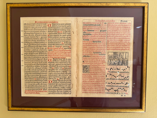 A framed and matted rare original print in Latin text from the 15th or 16th century, featuring images of musical notes and a religious church scene.