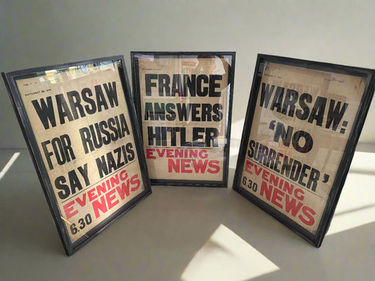 Three framed Evening News posters from WWII, with the headlines 'Warsaw: No Surrender', 'France Answers Hitler', and 'Warsaw for Russia'. Each poster is on rice paper and the frames are box framed with a white mount.
