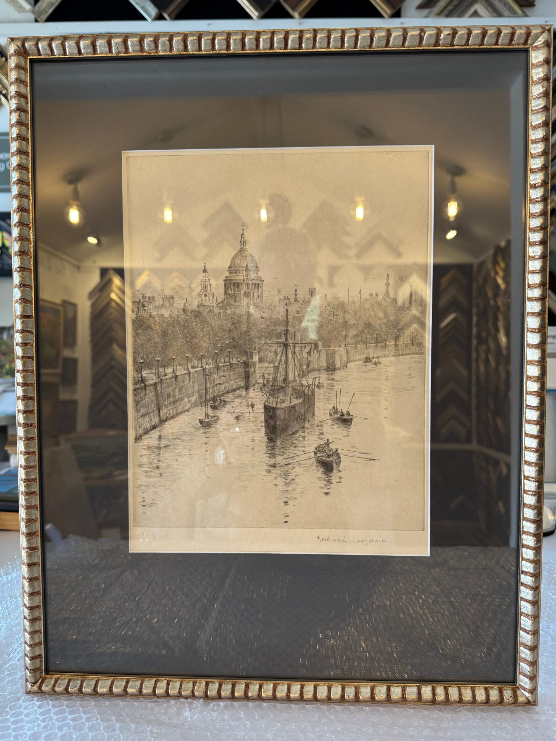 Framed black and white photograph of a cityscape with a gold frame.